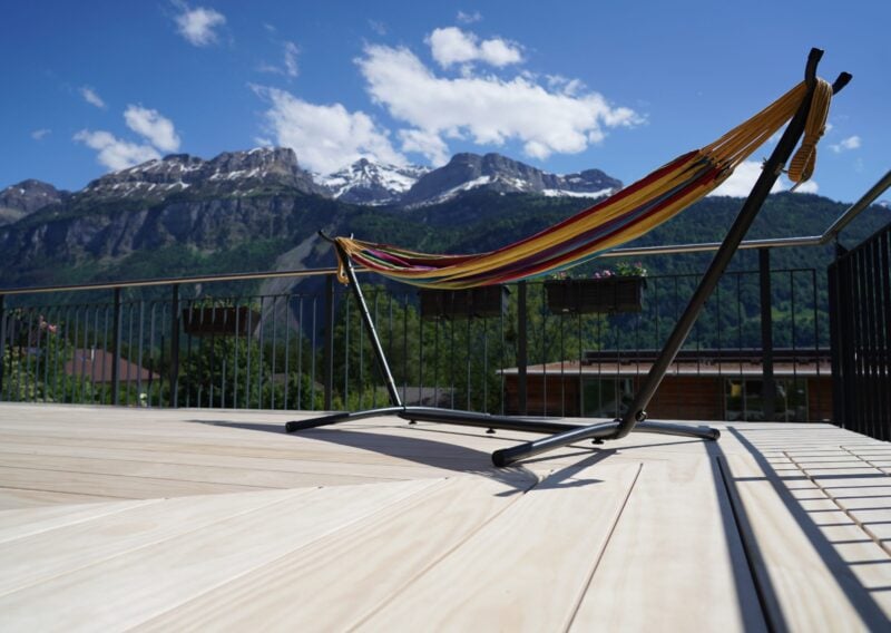 Hängematte auf einer Holzterrasse aus Accoya mit den Schweizer Alpen im Hintergrund.