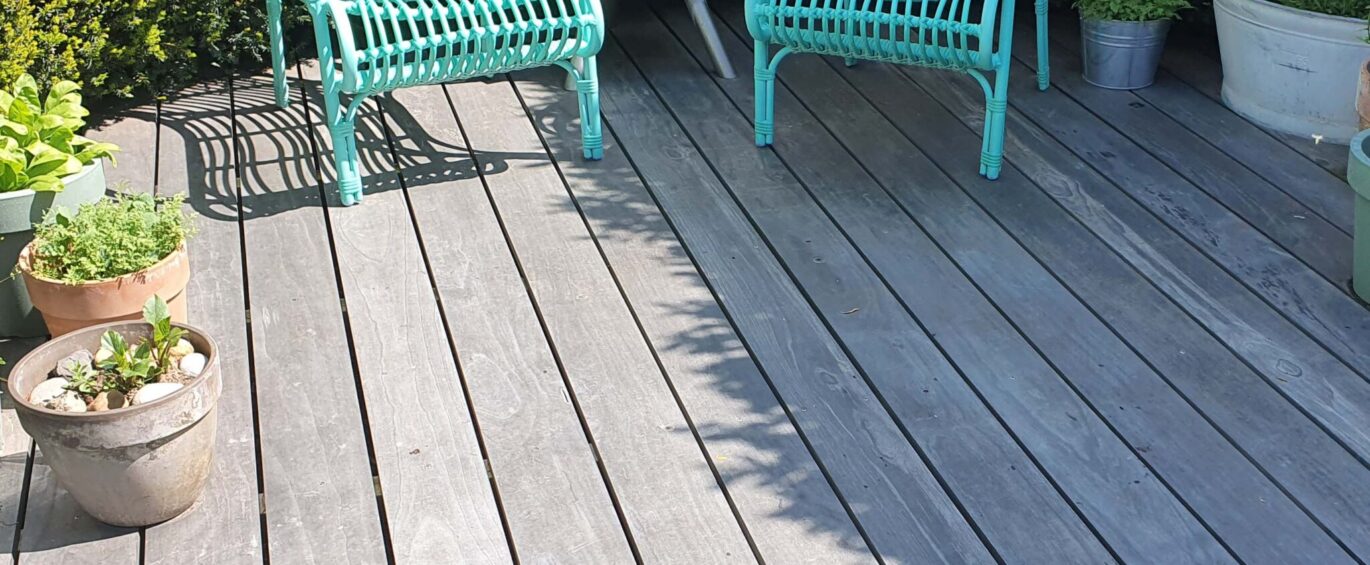 Accoya Color Gray Decking with green chairs far - square