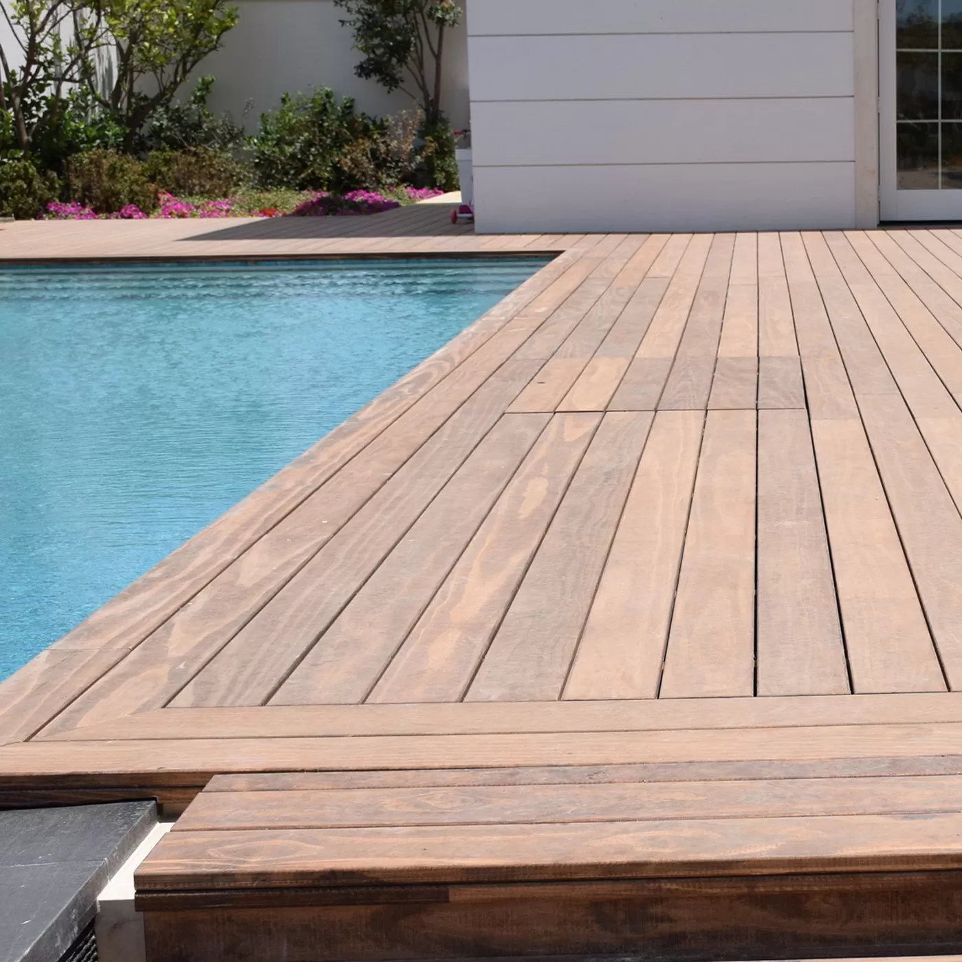 Dark coated swimming pool wood deck design